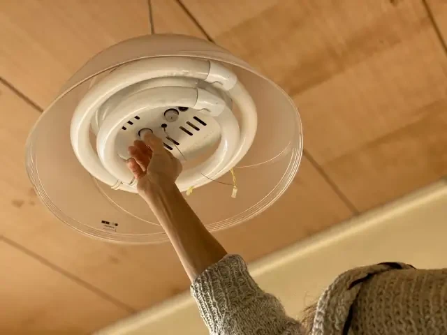 高齢者宅で照明の電球を交換する様子